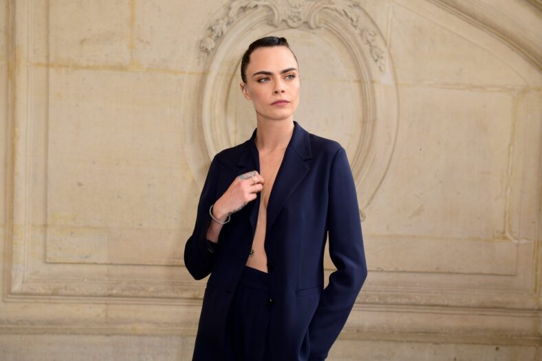 Cara Delevingne participa de evento de terno.