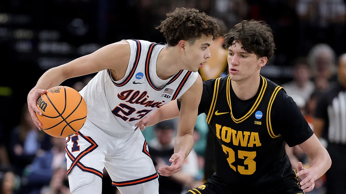 Keaton Wagler dribbling basketball while Isaia Howard defends during game.