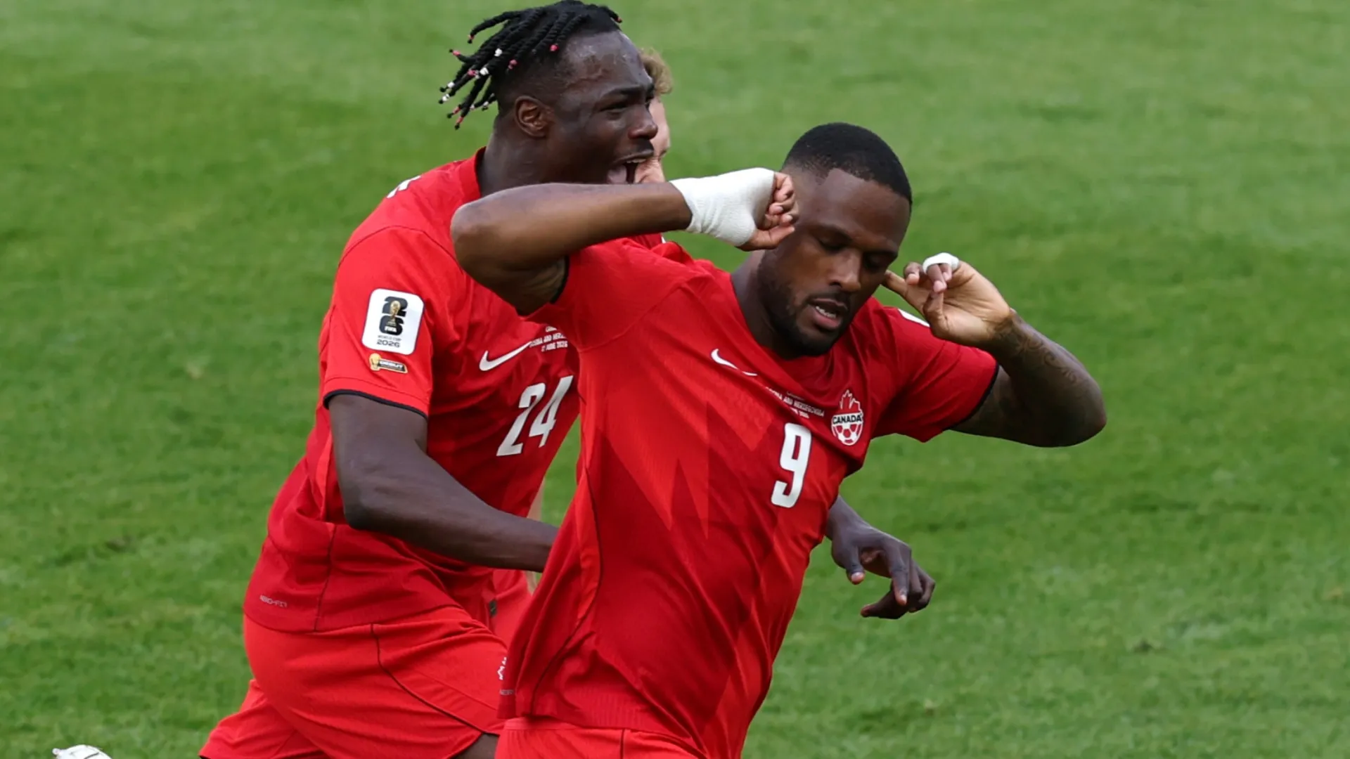 Cyle Larin nº 9 do Canadá comemora com Promise David nº 24 após marcar um gol.