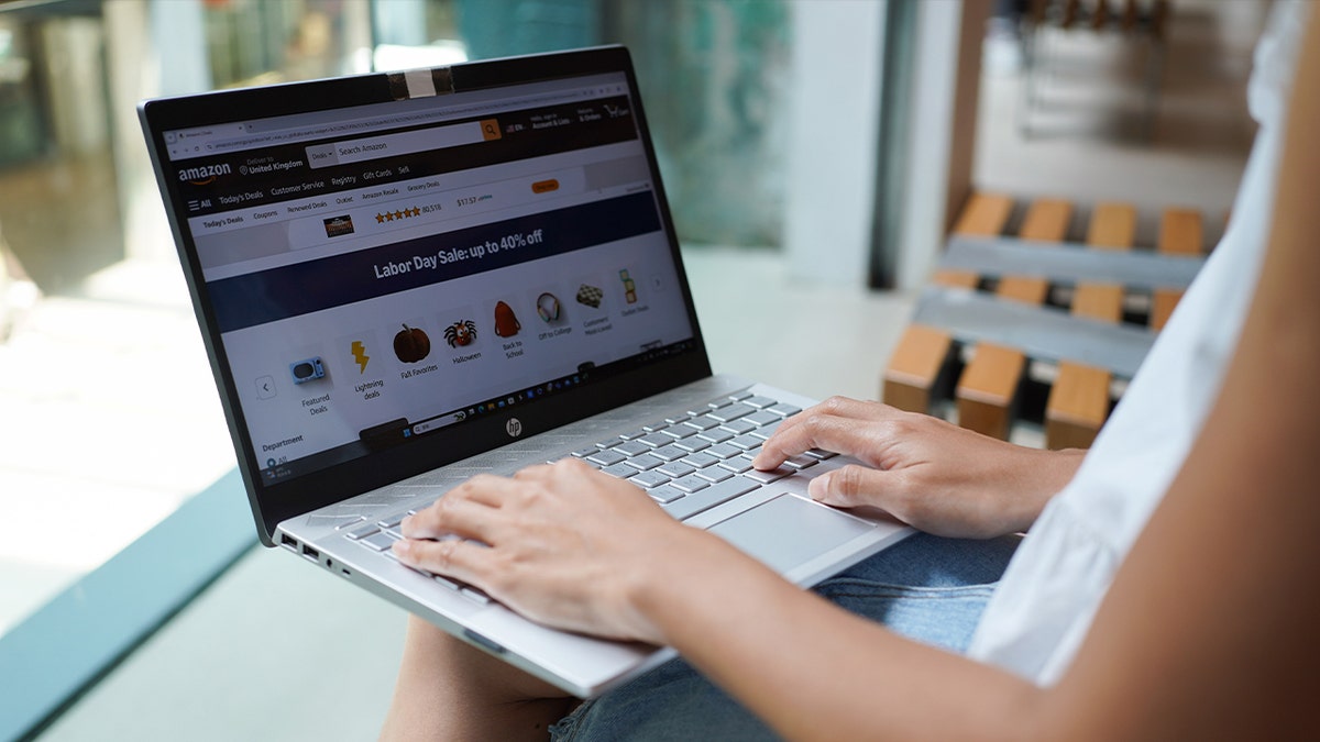 A woman browsing the Amazon website on her laptop.