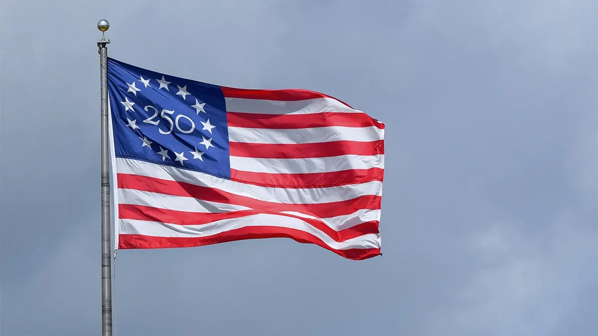 A detailed view of the special commemorative 250th anniversary American flag flying at a baseball stadium.