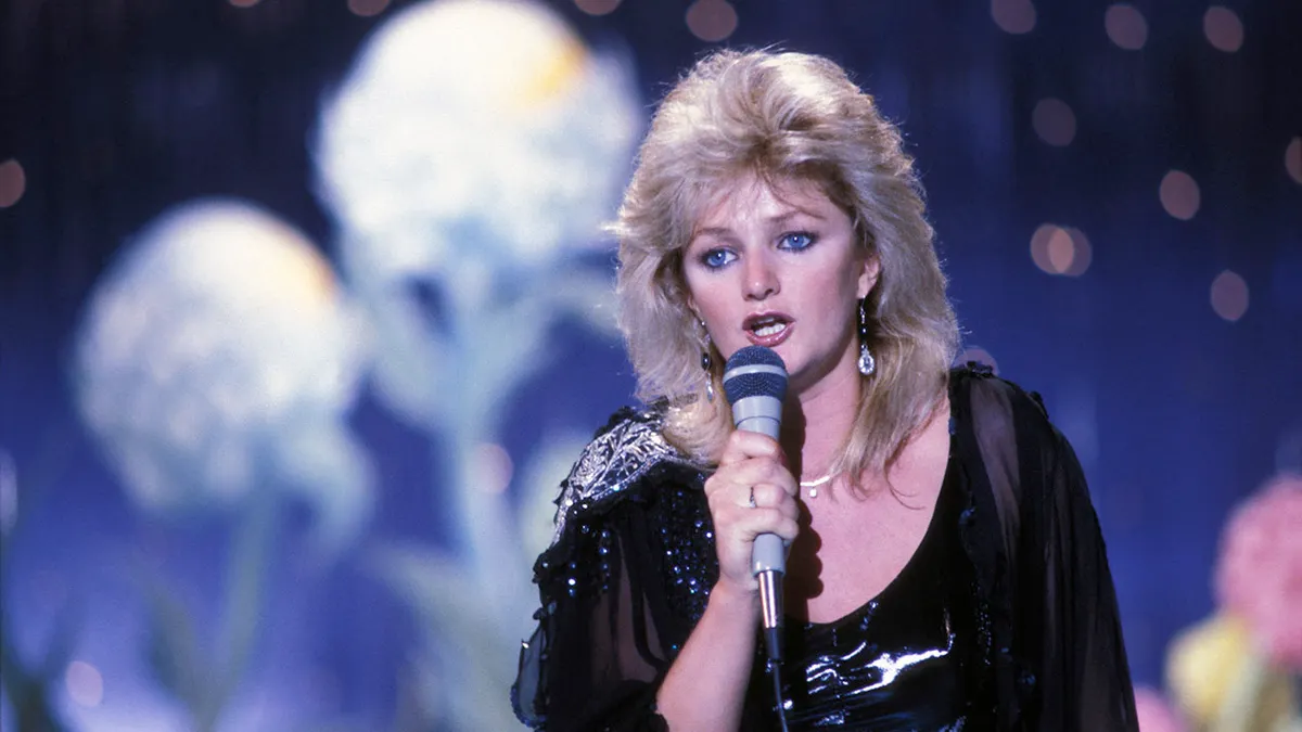 Bonnie Tyler singing into a microphone on the Champs-Elysée set in Paris