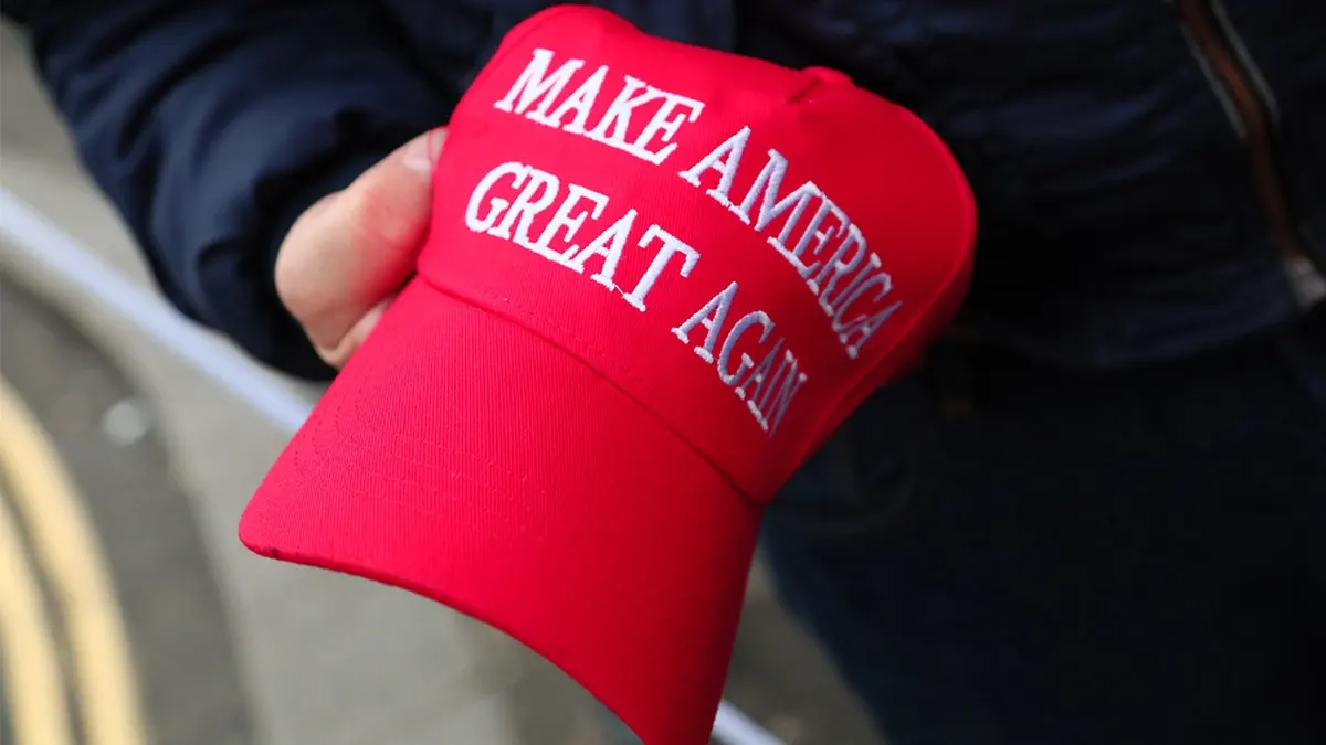 person-holds-MAGA-hat
