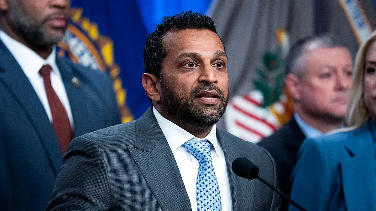 FBI Director Kash Patel speaking at a Department of Justice news conference with officials standing behind him