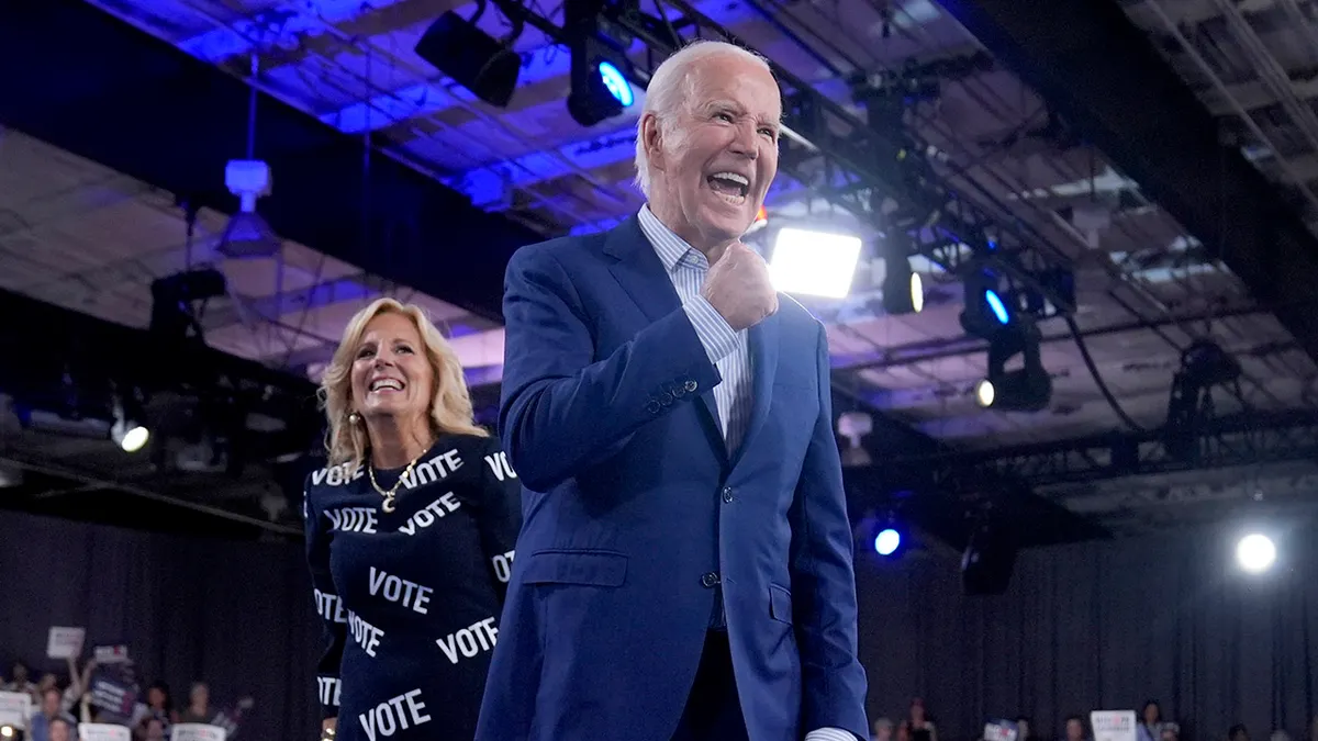 President Joe Biden and first lady Jill Biden walking off stage at a rally