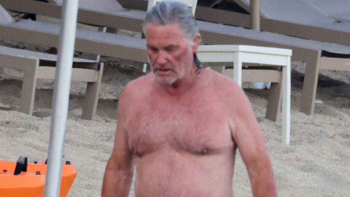 Kurt Russell sem camisa na praia.