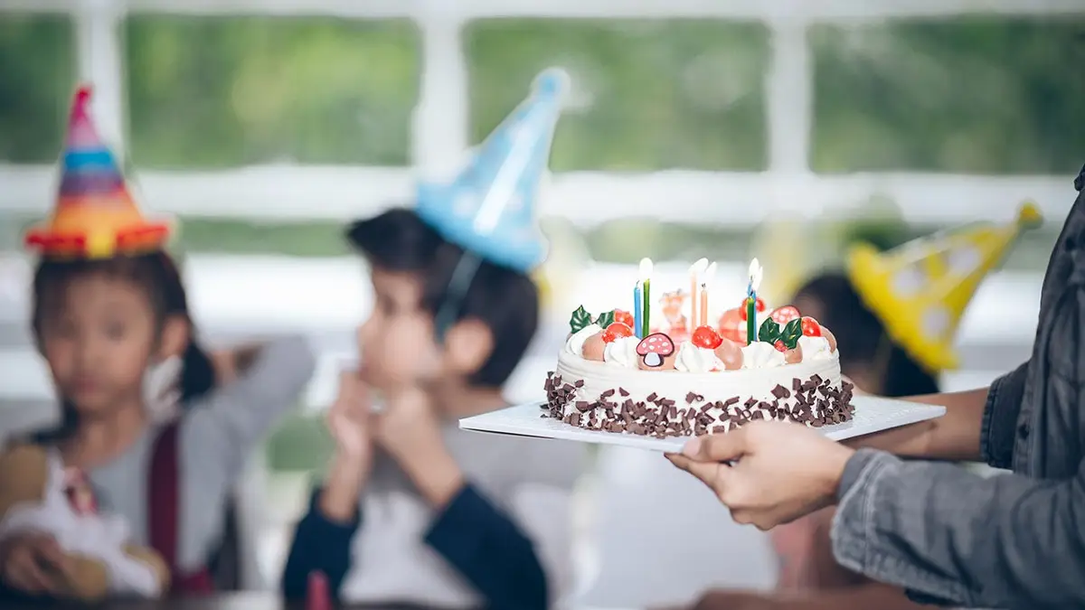 Birthday cake surrounded by a group of children