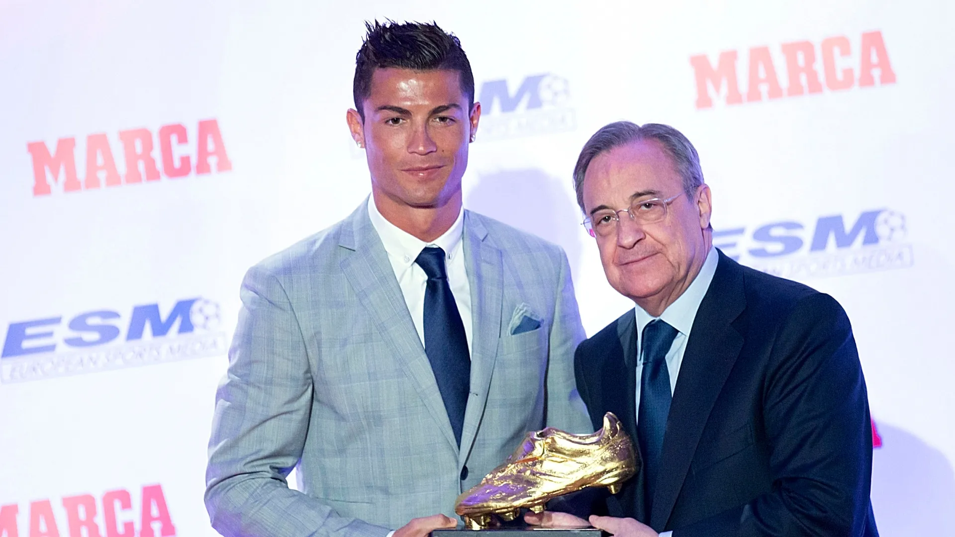 O jogador de futebol do Real Madrid, Cristiano Ronaldo (L), recebe das mãos do presidente do Real Madrid, Florentino Perez (R), sua quarta Chuteira de Ouro.