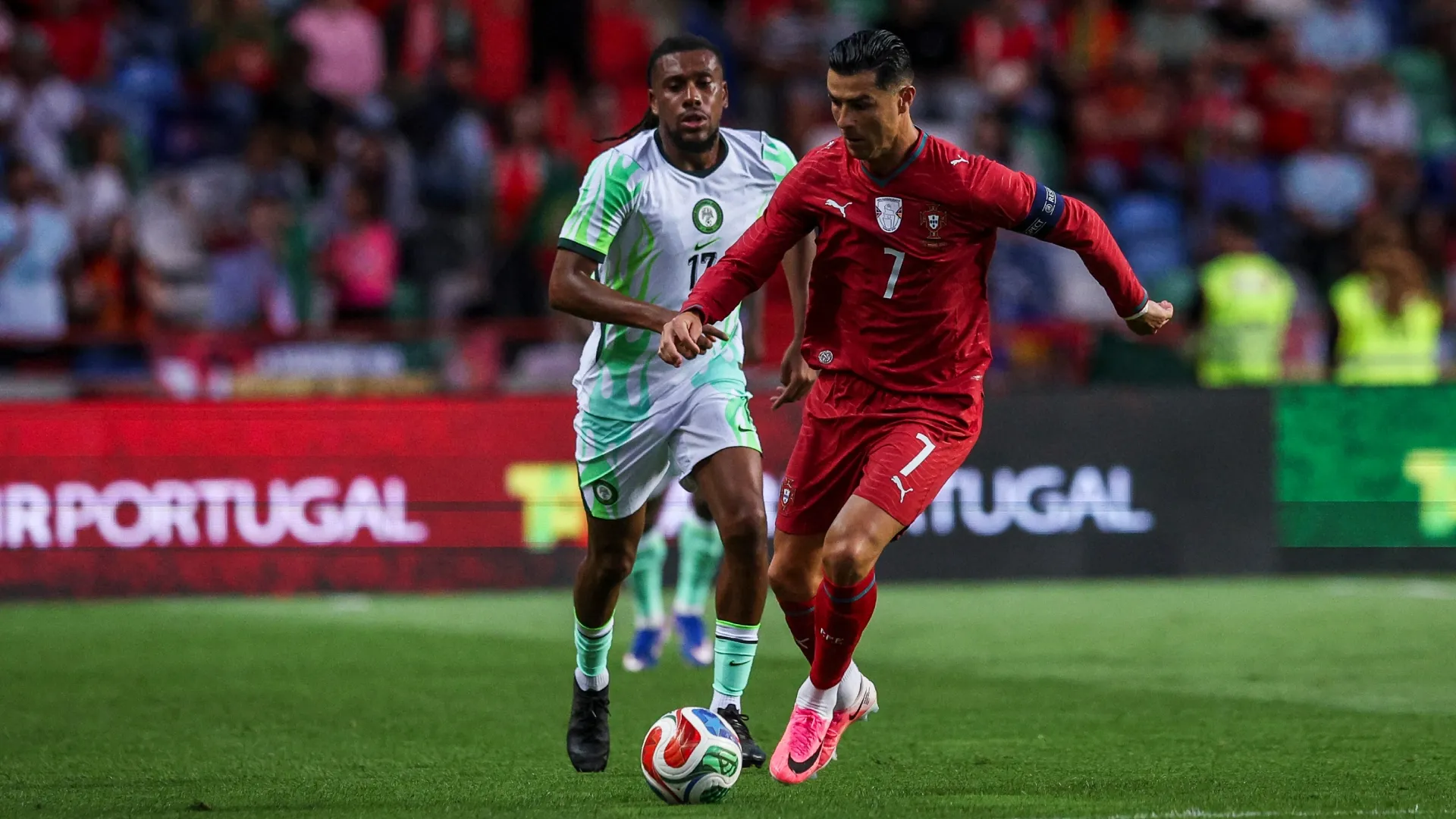 Cristiano Ronaldo de Portugal (R) tenta escapar de Alex Iwobi da Nigéria (L).