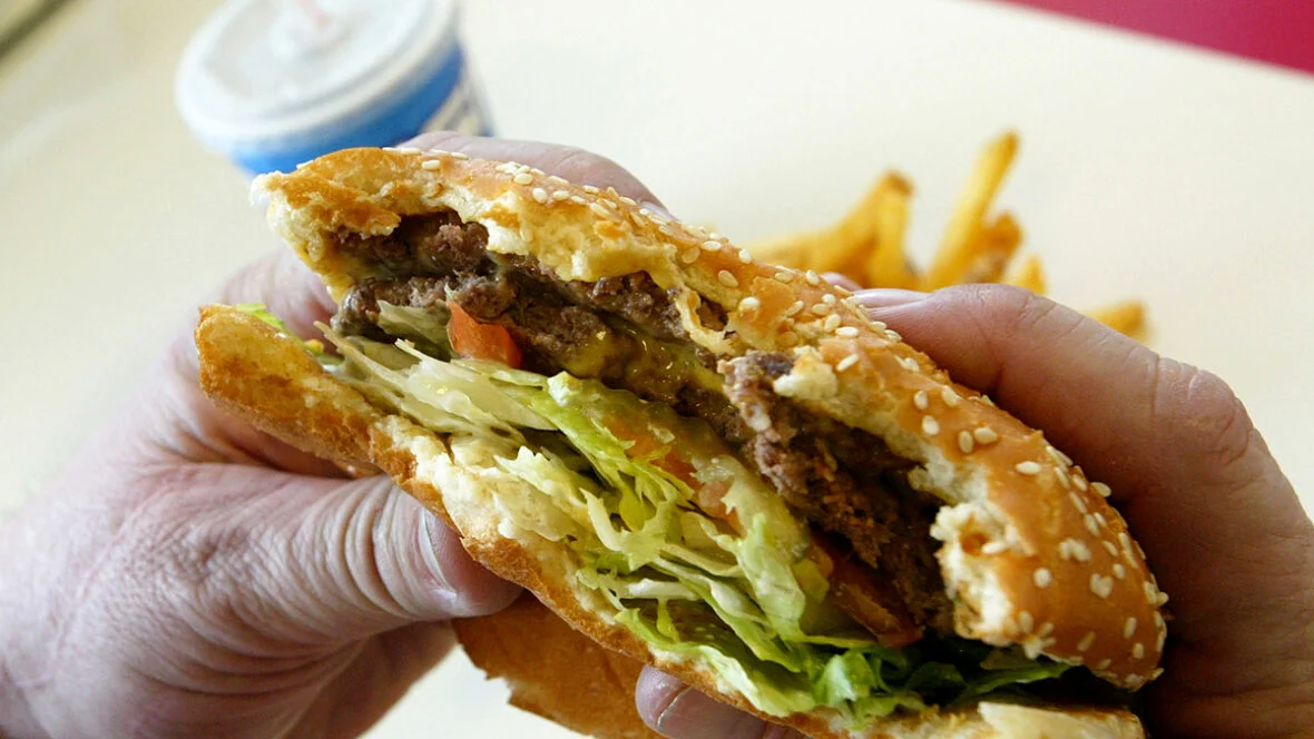 restaurantes de fast-food classificados Alguém segurando um hambúrguer que