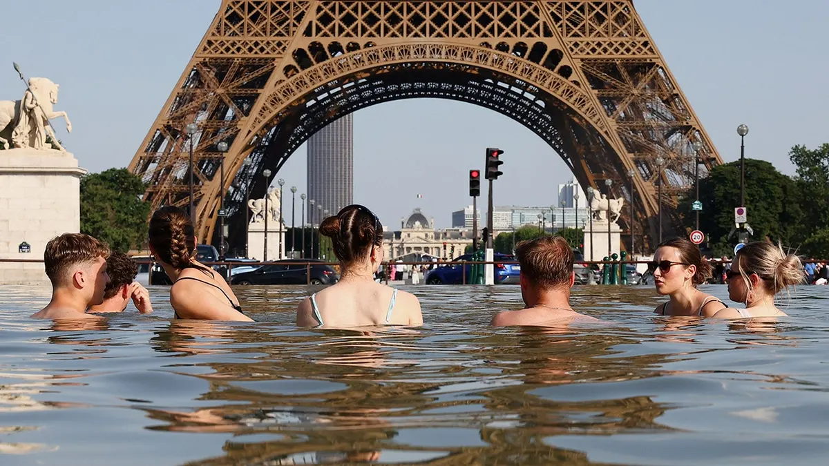 People cooling off in the Trocadero Fountain near the Eiffel Tower in Paris