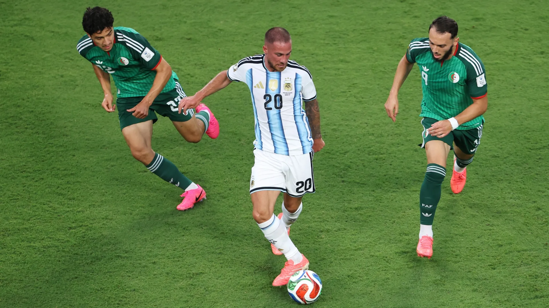 Alexis Mac Allister #20 da Argentina sendo pressionado por Ibrahim Maza #22 e Amine Gouiri #9 da Argélia.