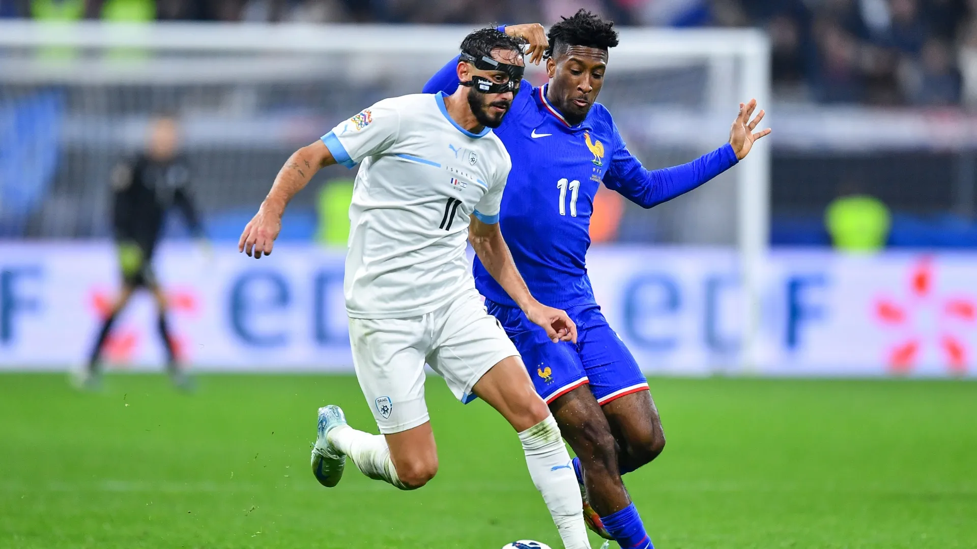 Sagiv Yehezkel, de Israel, corre com a bola sob pressão de Kingsley Coman, da França.