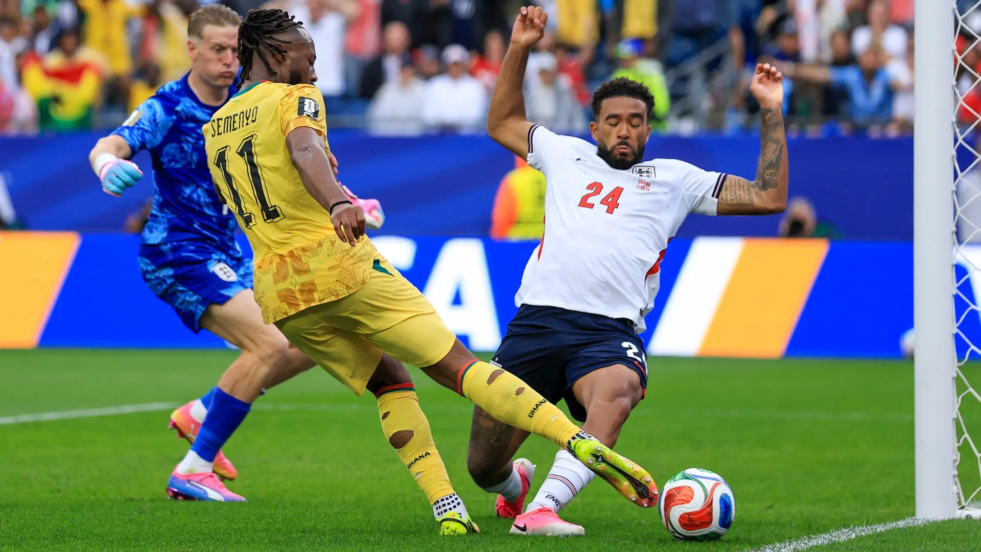 Antoine Semenyo nº 11 de Gana tenta chutar, bloqueado por Reece James nº 24 da Inglaterra.