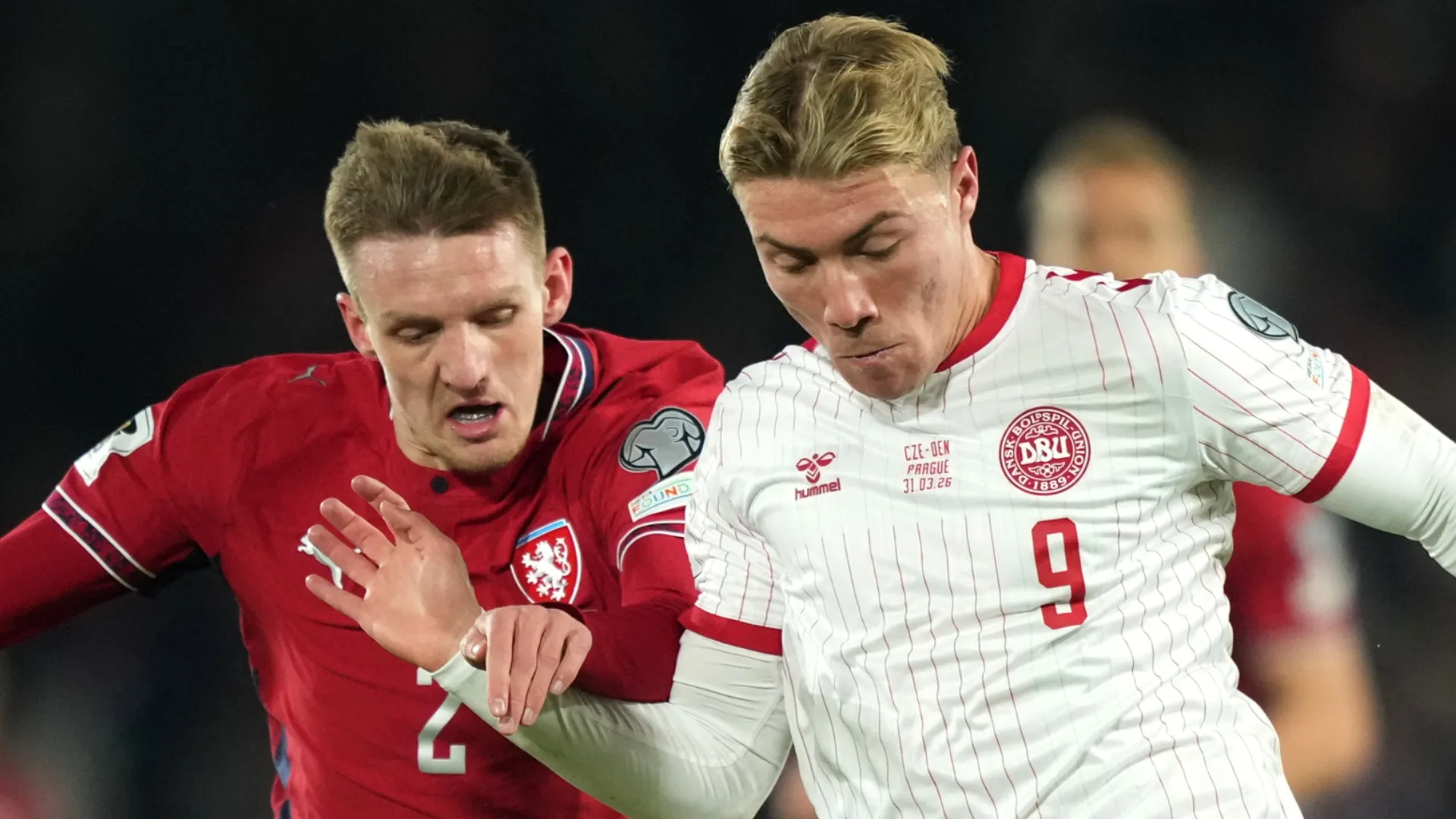 Rasmus Hojlund, da Dinamarca, corre com a bola sob pressão de Stepan Chaloupek, da República Tcheca.
