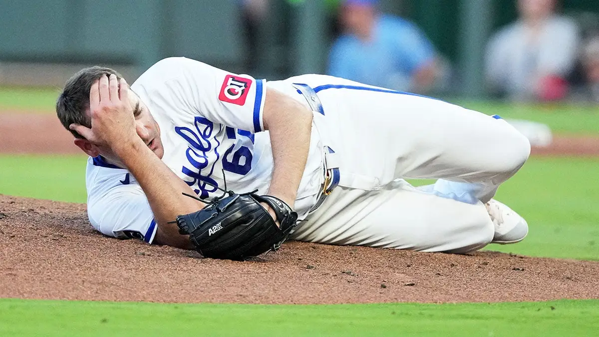 Kansas City Royals pitcher Seth Lugo dropping to the mound after being hit by a line drive.