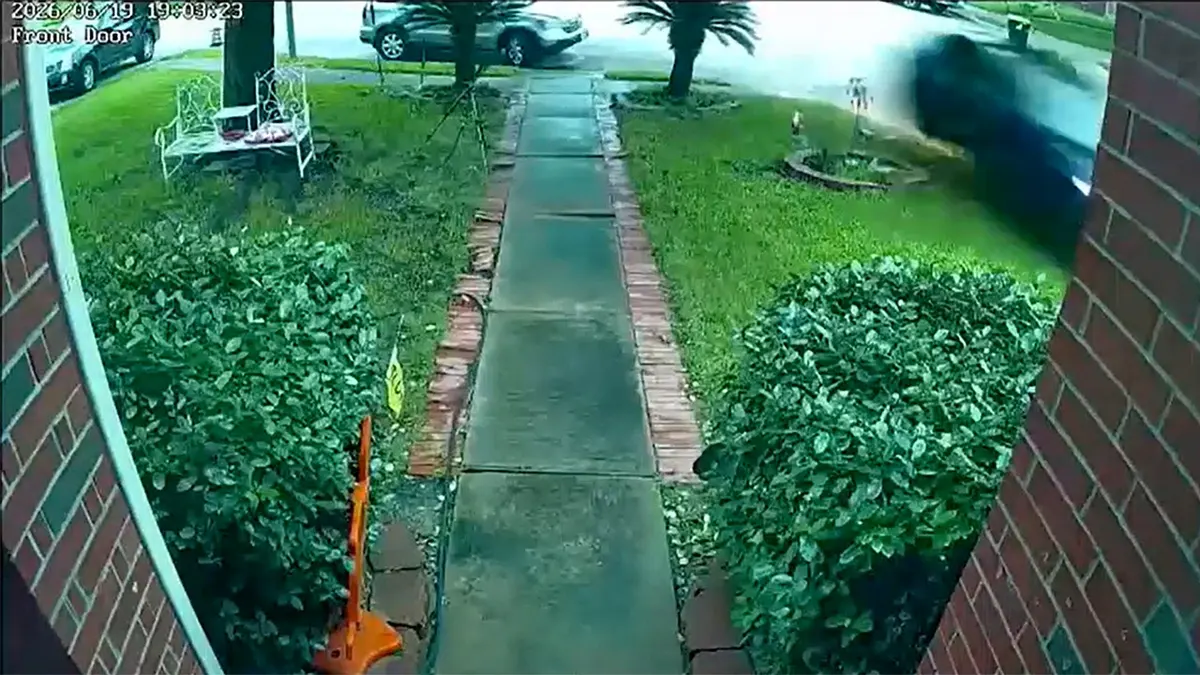 Surveillance footage of a car crashing into a house