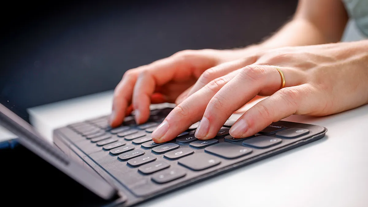 Woman typing on a keyboard.