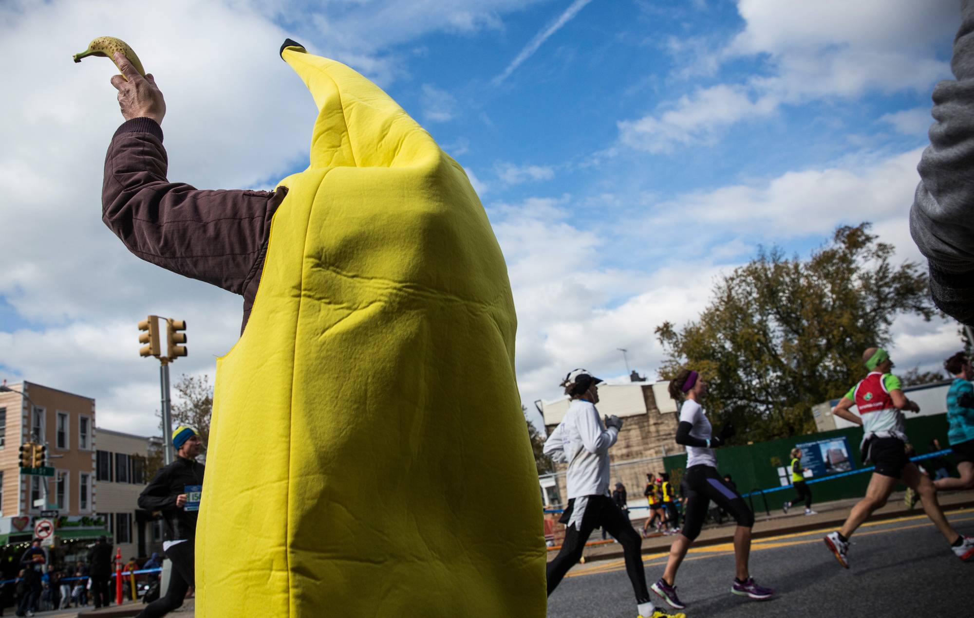 A volunteer in costume hands out bananas to runners participating in the TCS New York City Marathon on November 2, 2014 in the Park Slope neighborhood of the Brooklyn Borough of New York City. (Photo by Andrew Burton/Getty Images)