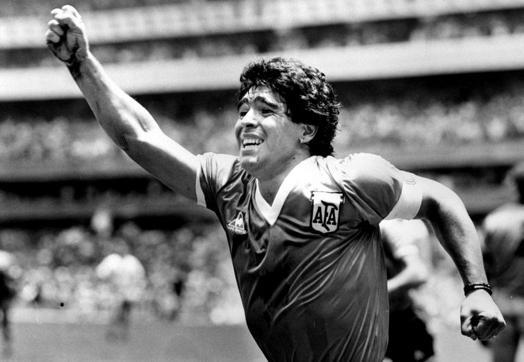 O astro argentino Diego Maradona levanta o braço ao ar após marcar o gol da vitória contra a Inglaterra nas quartas de final da Copa do Mundo no México, em 22 de junho de 1986.
REUTERS/POOL/Ted Blackbrow