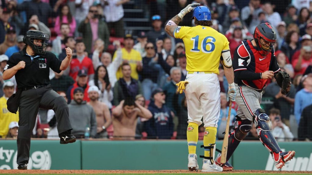 Jarren Duran taps his helmet as Jen Pawol calls him out on strikes at Fenway Park.