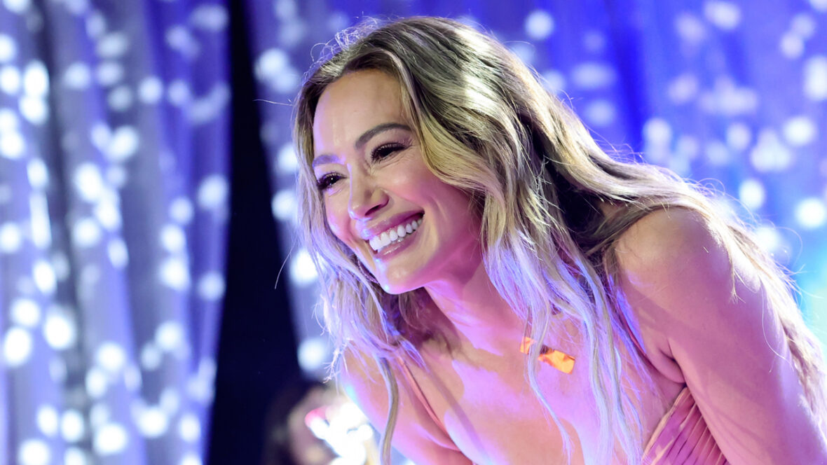 filmagem hilariante Hilary Duff sorri enquanto se apresenta no palco