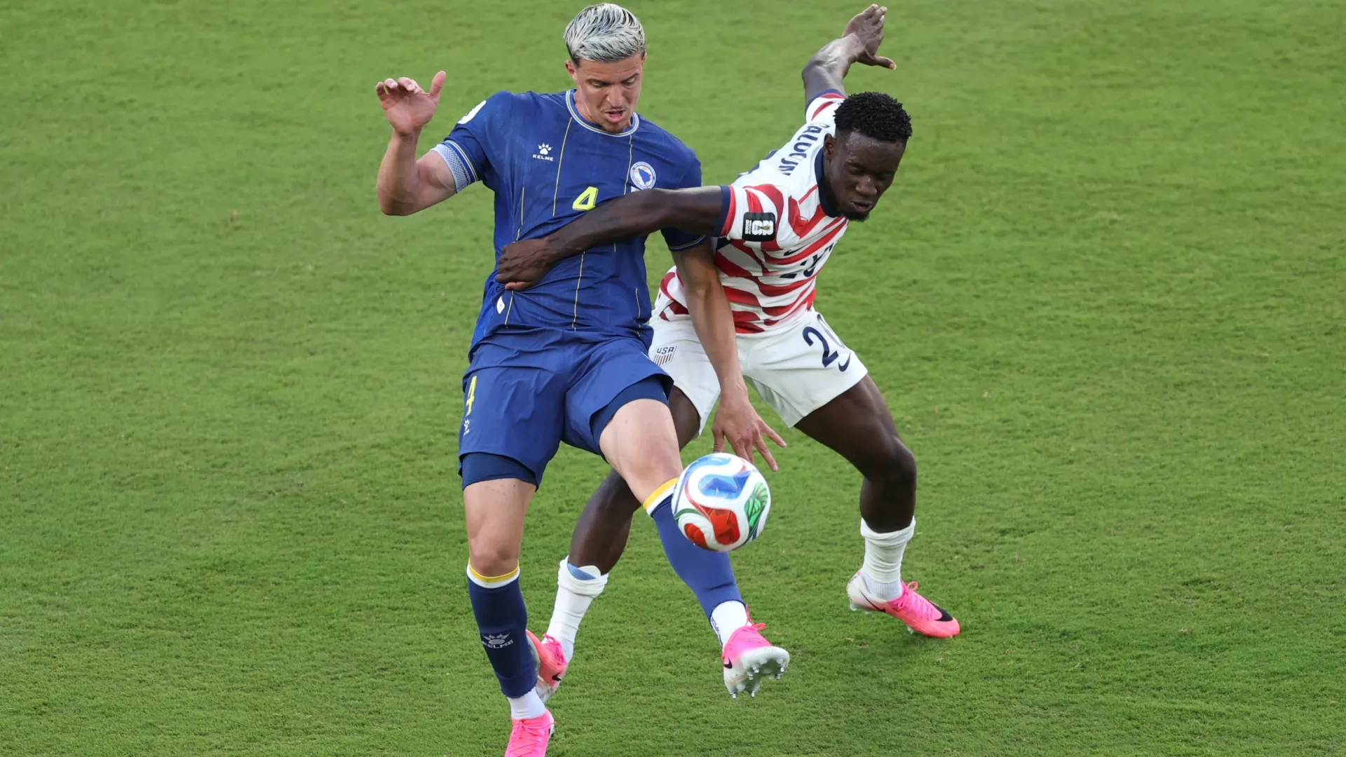 Folarin Balogun nº 20 dos Estados Unidos comete falta em Tarik Muharemovic nº 4 da Bósnia e Herzegovina.