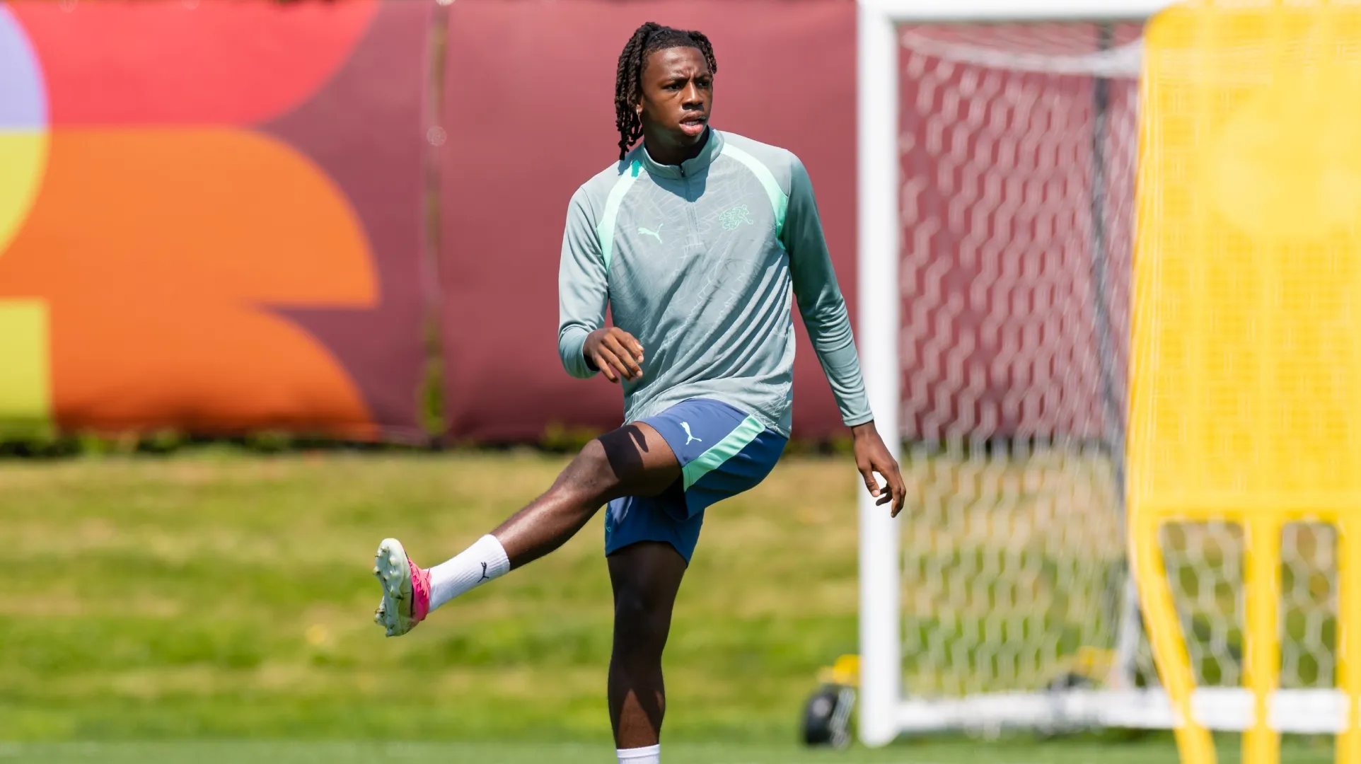 Manzambi Johan nº 9 da Suíça se alonga durante um treino.