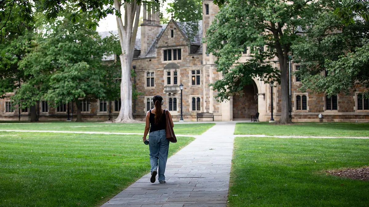 A student walks through the Law Quad at the University of Michigan.