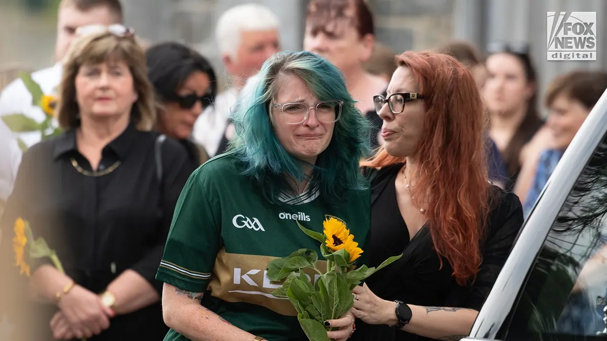 Devon is consoled at a funeral inside St. Mary
