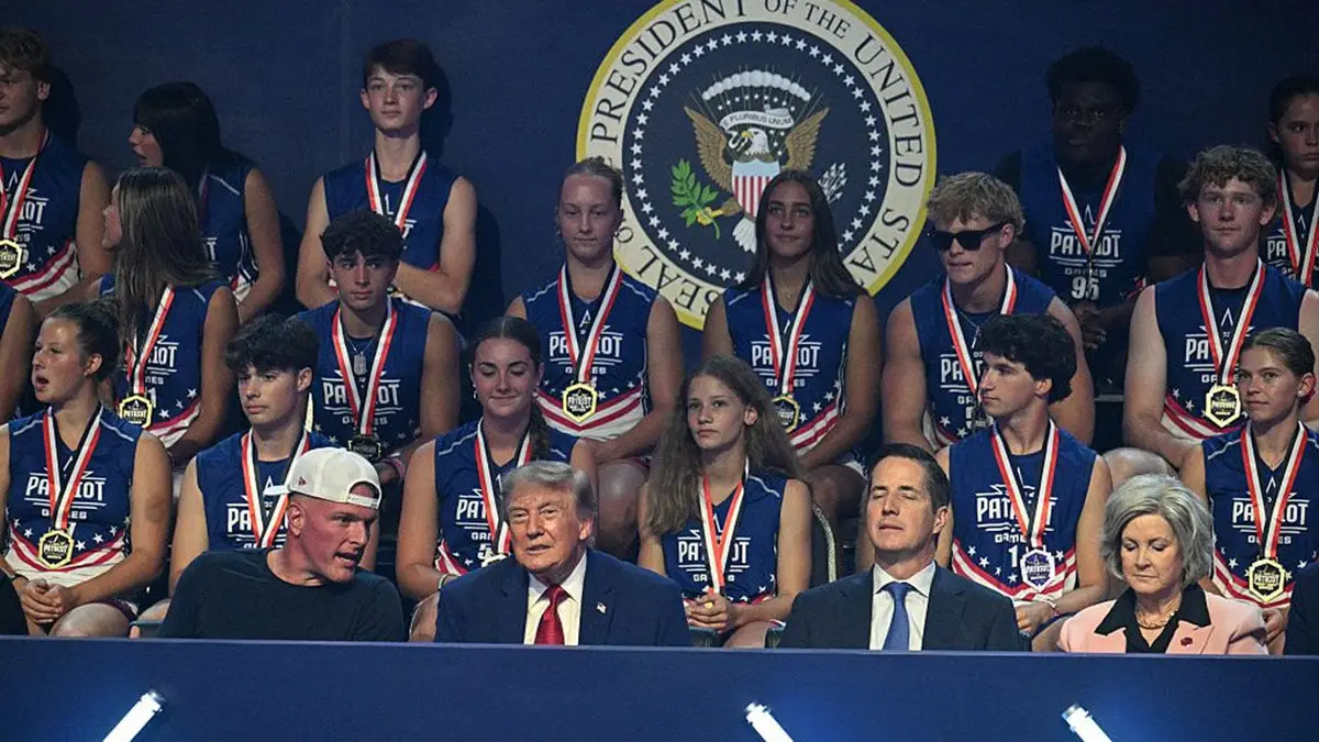 President Donald Trump stands with Pat McAfee and Susie Wiles at the Patriot Games finals.