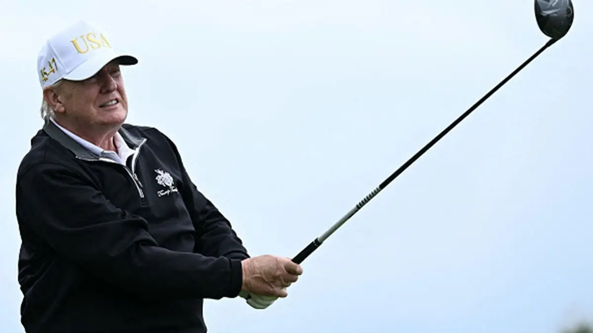 Donald Trump watches his drive on a golf course in Scotland.