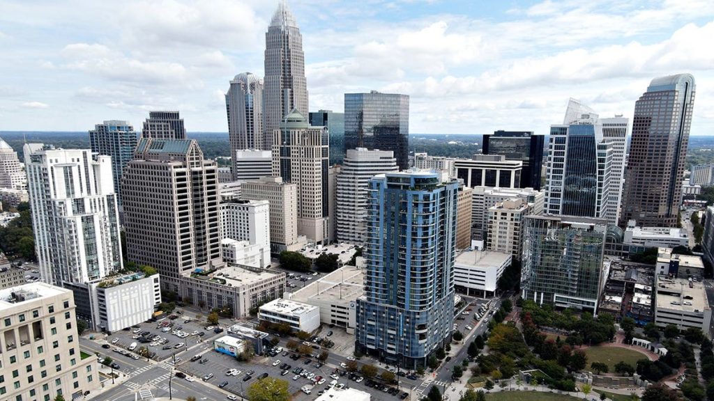 Aerial view of downtown Charlotte skyline under clear skies.