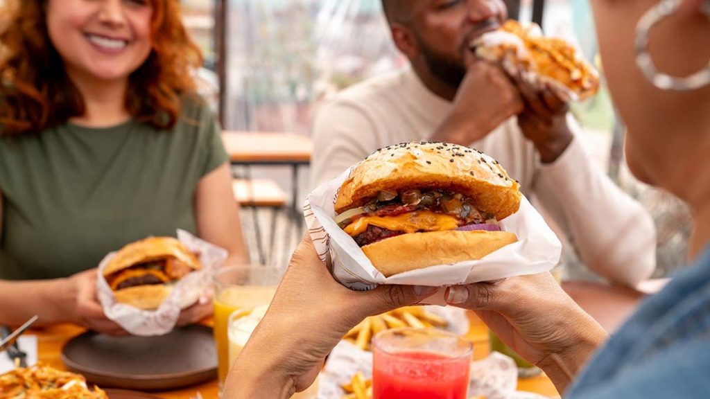 A group of friends eats burgers together.