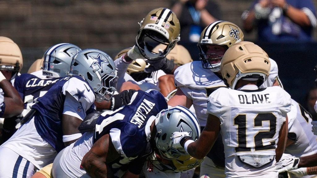 A New Orleans Saints helmet is ripped off during a scrum at joint practice.