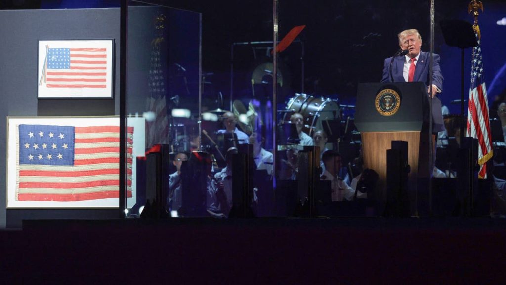 Donald Trump speaks beside historic American flags during Fourth of July celebrations.