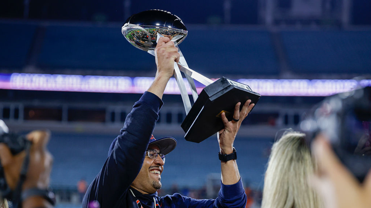 Tony Elliott lifts the trophy after the TaxSlayer Gator Bowl in Jacksonville.