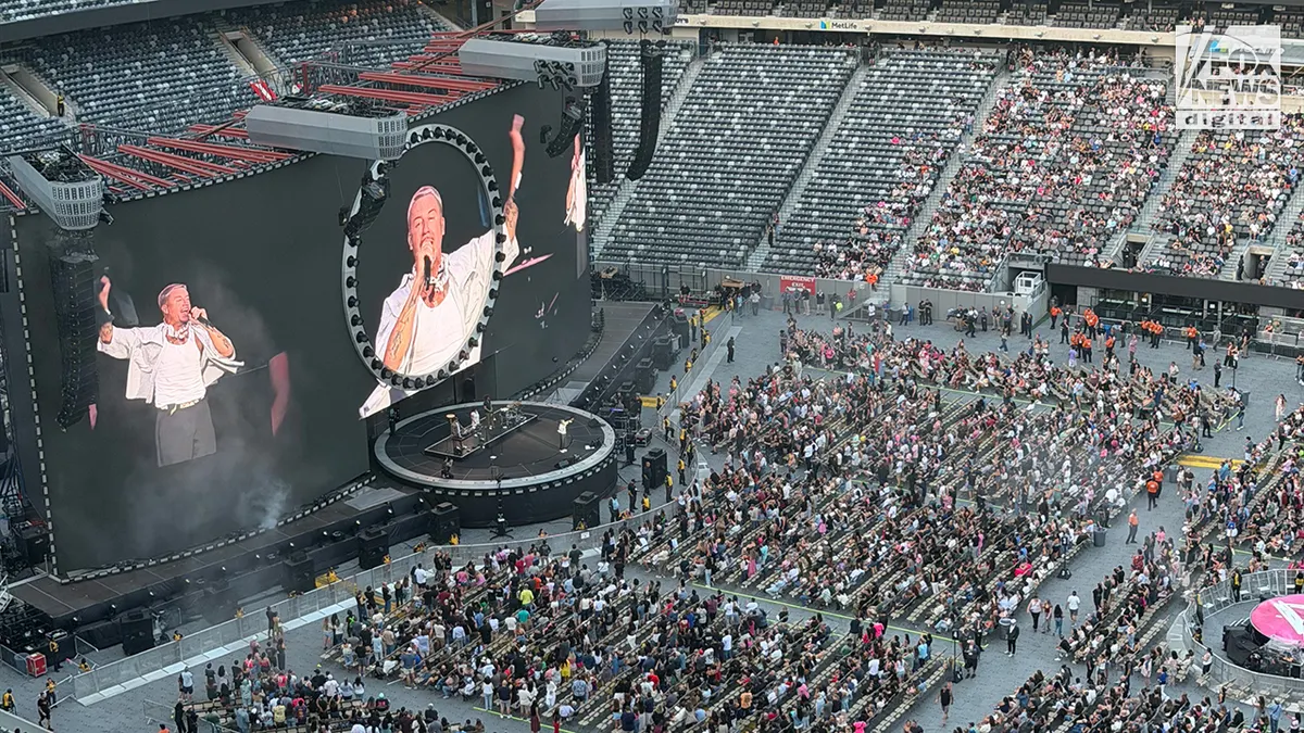 Macklemore performs onstage at MetLife Stadium while opening for Ed Sheeran.