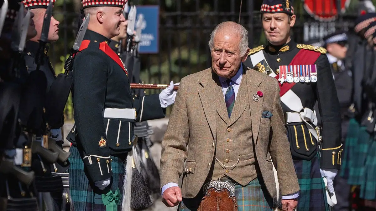 King Charles in formal Scottish clothing inspecting a regiment.