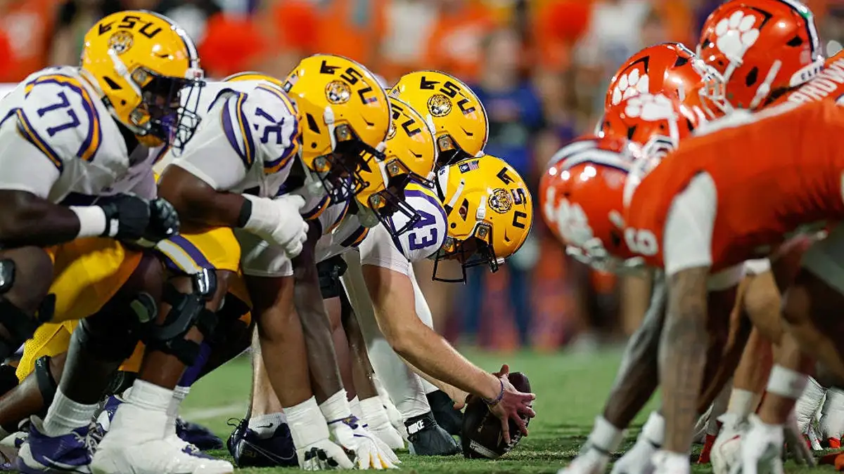 LSU Tigers and Clemson Tigers players face off at the line of scrimmage.