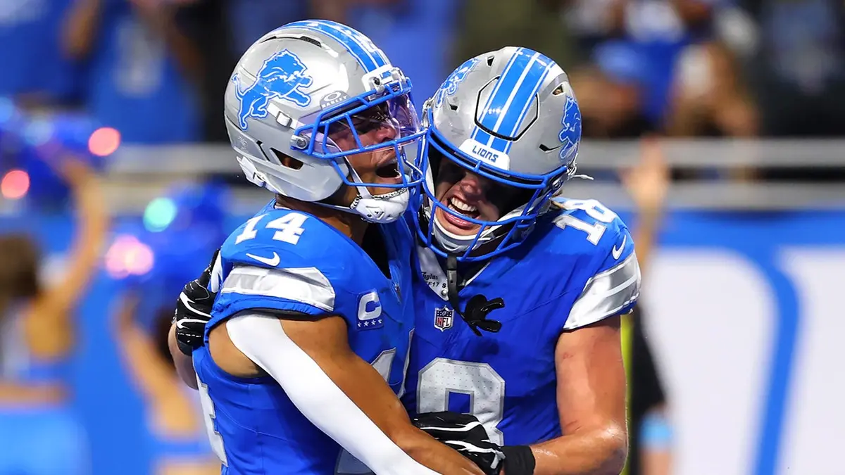 Amon-Ra St. Brown celebrates after scoring a touchdown with Isaac Teslaa during overtime.