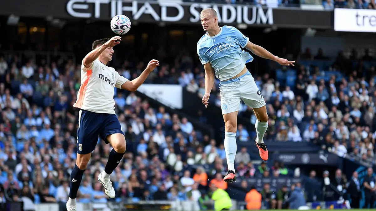 Erling Haaland heads the ball during Manchester City vs. Coventry City match at Etihad Stadium.