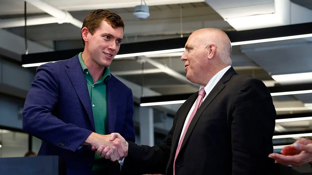 Garrett Langley shaking hands with Councilor Ed Flynn at an event in Boston
