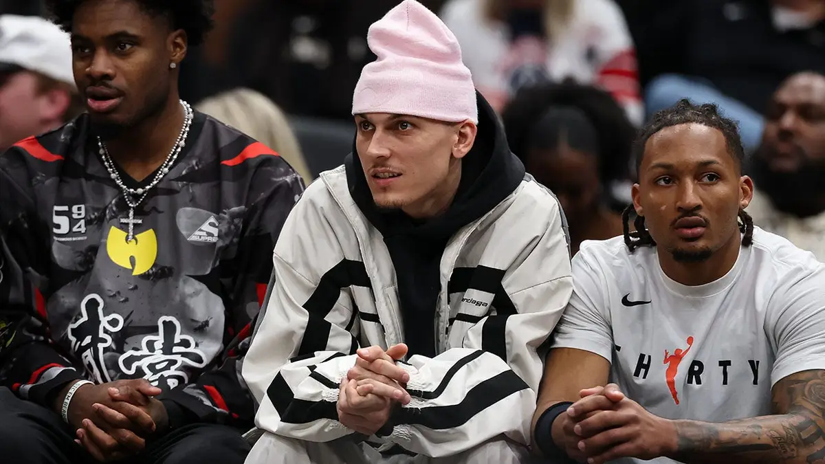 Tyler Herro sits on the bench in street clothes during a Miami Heat game against the Washington Wizards.