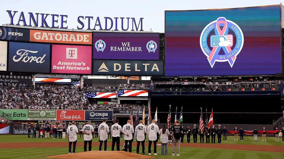 Members of the 2001 New York Yankees standing on the field during a 9/11 commemoration