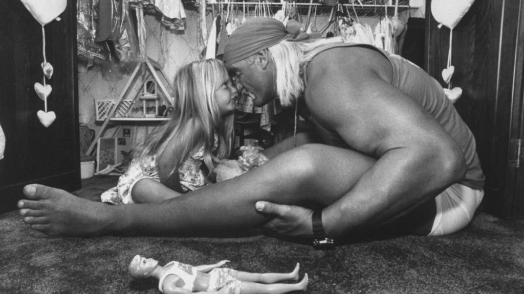Wrestler Hulk Hogan affectionately rubbing noses w. his 3-yr-old daughter Brooke as they facing each other next to a Ken-type doll on the floor in front of her toy closet at home. (Photo by Acey Harper/Getty Images)