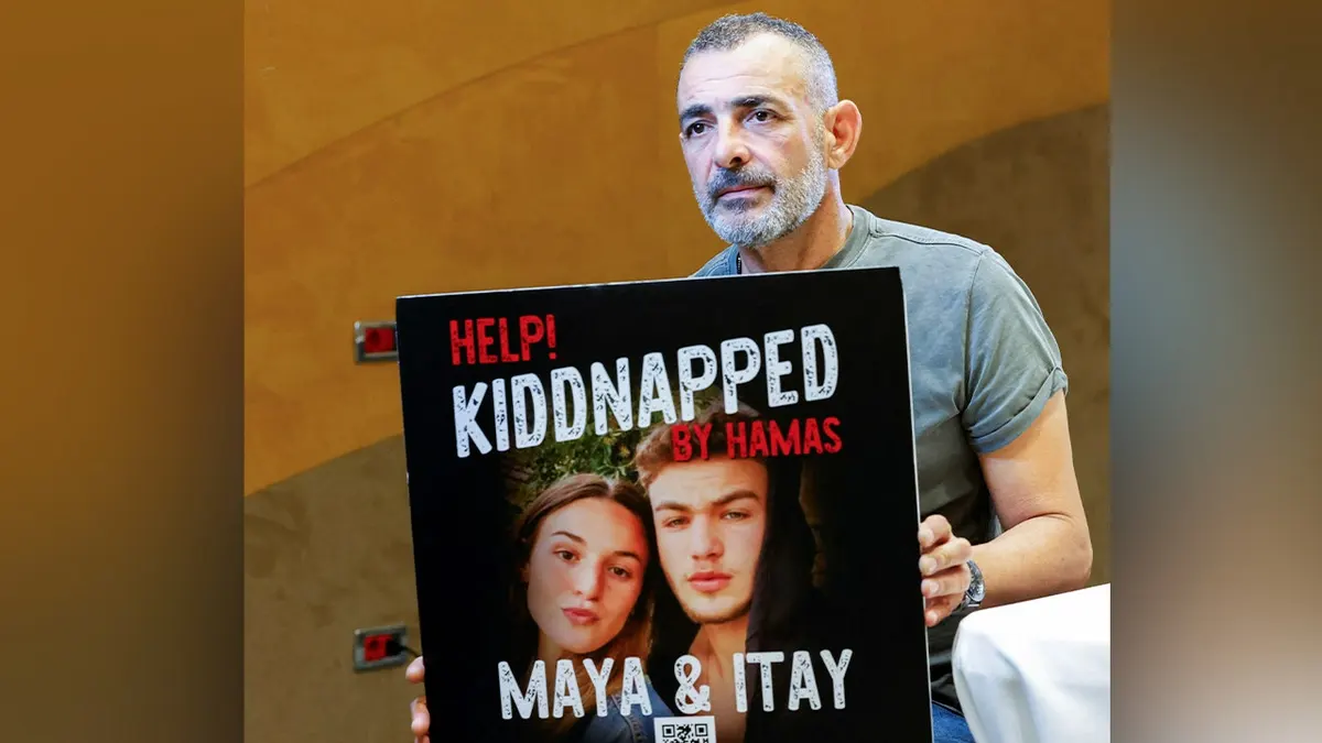 Ilan Regev shows a picture of his children Maya and Itay, who were hostages in Gaza