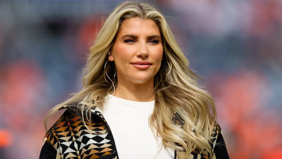 Melanie Collins walks on the field before a game at Empower Field at Mile High.
