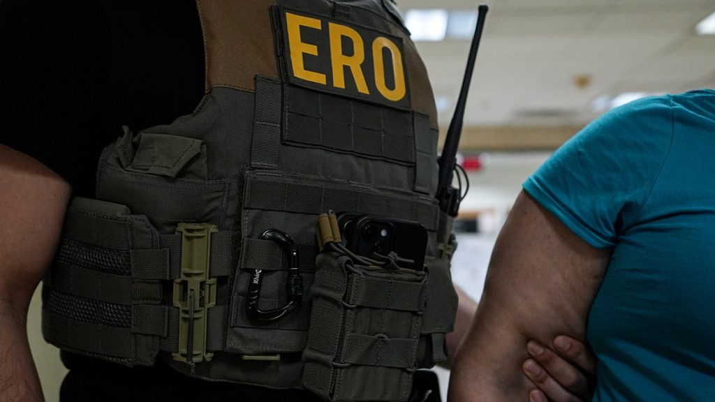ERO agent holding an illegal immigrant