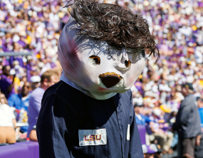 LSU’s Mike the Tiger stalks referee while dressed as Michael Myers, appears to be steered away by staffer